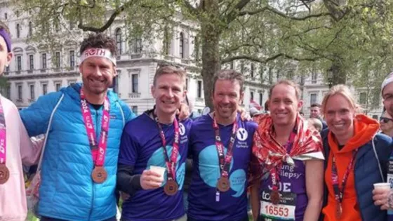 Group of London Marathon posing with their medals