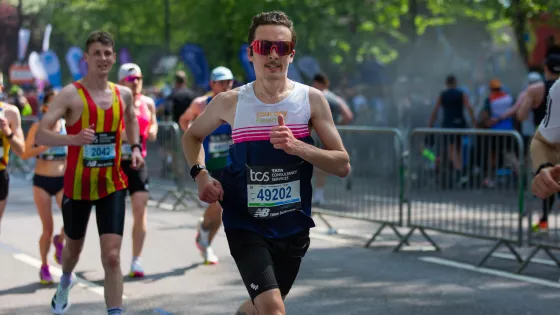 A marathon runner in sunglasses, Jack, gives a thumbs up.