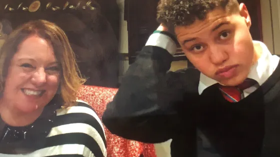 A mother and son stand for a selfie.