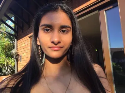 A young woman, Anoushka, looks into the camera for a selfie.