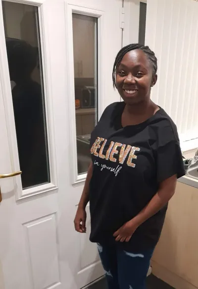 Lauren, a young woman in a 'Believe' t-shirt, poses for a photograph.