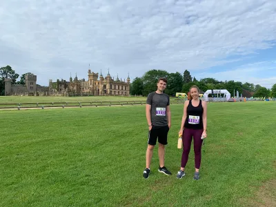 A man and woman representing Young Epilepsy at a sporting event smile in a field.