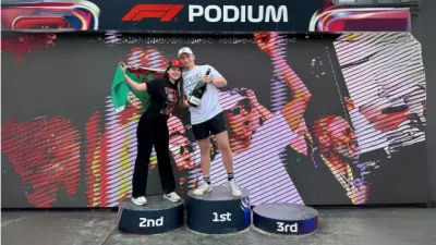 Young girl poses on a racing podium with her partner