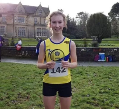 A runner shows off her trophy on a summer's day.