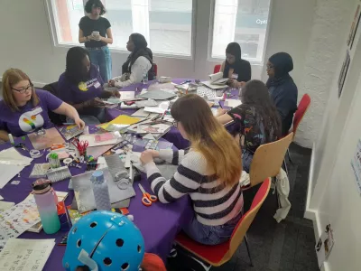 Young people from Young Epilepsy sit around a cluttered table creating a pamphlet.