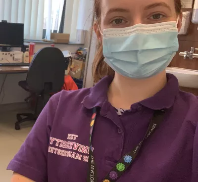 A young medical professional wears a cotton mask in an office.