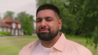 A young man with a beard, Zaid, looks into camera wearing a salmon shirt and white t-shirt.