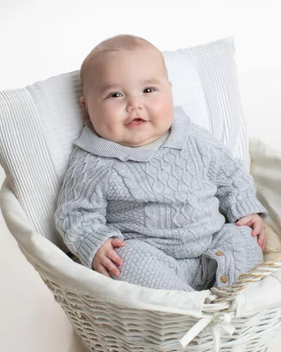 A baby smiles in a professional portrait.