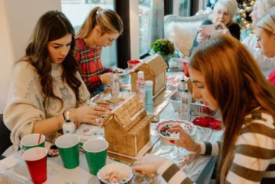 Three teenage girls design gingerbread houses.