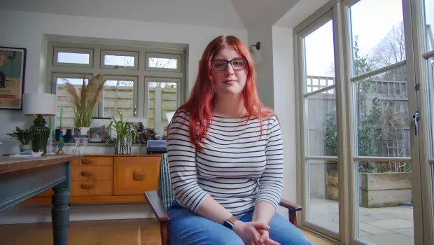 young woman with red hair looking at the camera