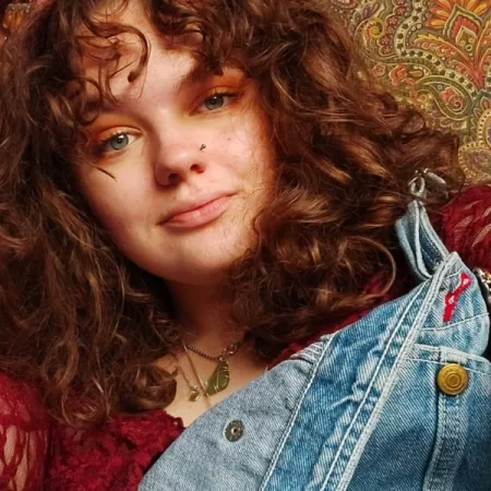 Photograph of young woman looks serious at the camera