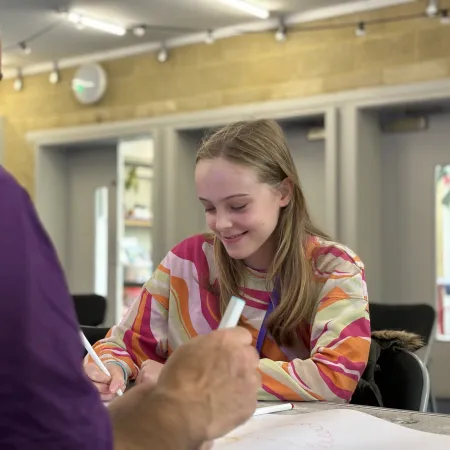 Young girl working at desk with Youth Support Coordinator