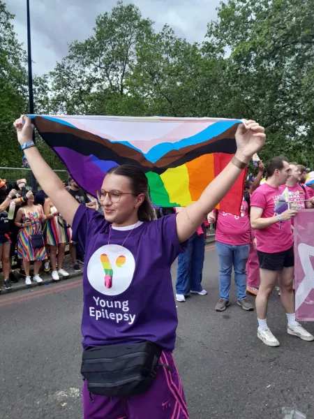 Young woman flying the Pride flag for Young Epilepsy