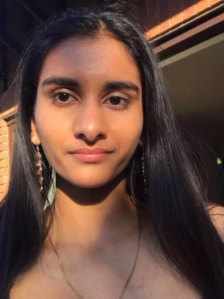 A young woman, Anoushka, looks into the camera for a selfie.