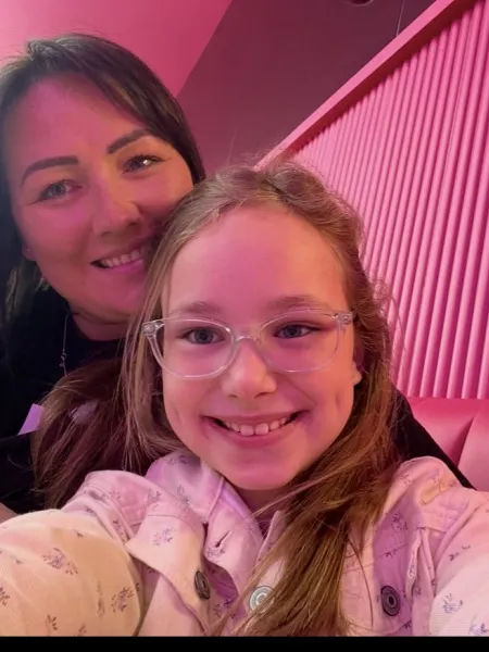 A mother and daughter smile in a selfie.