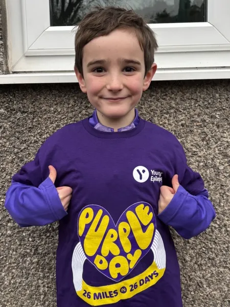 Boy smiling, doing thumbs up in a 26 miles tshirt